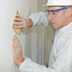 Man removing popcorn wall texture