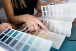 a person looking at a foldable brochure of paint samples