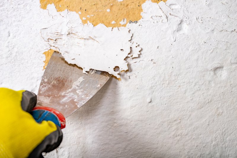 person peeling away cracked paint 